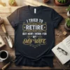 Humorous "I Tried To Retire But Now I Work For My Wife" text design on a dark t-shirt, featuring vintage-style