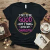 Black t-shirt with "I TRY TO BE GOOD BUT I TAKE AFTER MY GRANDMA" in pink and white text within