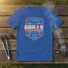 Blue t-shirt with neon-style text reading "I TURN GRILLS ON" in a shield graphic, for barbecue enthusiasts