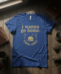 Blue t-shirt with gold text "i wanna go home." and a house graphic within a wreath
