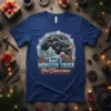 I Want A Monster Truck For Christmas text with a monster truck graphic, snow, and presents, on a blue t-shirt