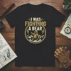 Black t-shirt with "I Was Fighting A Bear" text and a graphic of a grizzly bear in mountains, lightning bolts