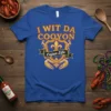 Blue t-shirt with "I Wit Da Cooyon Cajun Life" text and Cajun-themed graphics including crab claws and fleur-de-lis