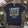 I Wonder What My Job Description Says Today quote on a navy t-shirt, featuring distressed gold and white typography and