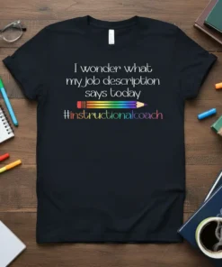 Black t-shirt with white text "I wonder what my job description says today" above a rainbow pencil graphic and "#instructionalcoach"