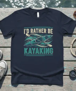 I'd Rather Be Kayaking text with a graphic of a kayak and paddles on a navy t-shirt