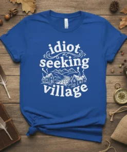 White text 'idiot seeking village' with a charming village graphic on a royal blue t-shirt