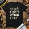 Black t-shirt with white distressed text "IDK, I JUST WORK HERE" and industrial graphics like gears and a hammer