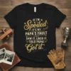 Humorous "If I'm Spoiled It's My Papa's Fault" quote on a black t-shirt with golden yellow and blue typography