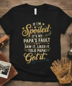 Humorous "If I'm Spoiled It's My Papa's Fault" quote on a black t-shirt with golden yellow and blue typography