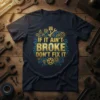 If It Ain't Broke Don't Fix It quote on a navy blue t-shirt with gold and blue mechanical graphics