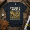 T-Shirt with white text "IF WE GET IN TROUBLE" above "IT'S MY Papa's Fault" in gold with gear graphics, and