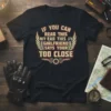 Black t-shirt with "IF YOU CAN READ THIS MY EAD THIS AY GIRLFRIEND SAYS YOUR TOO CLOSE" text and winged