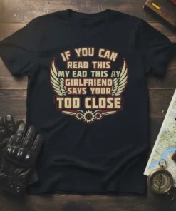 Black t-shirt with "IF YOU CAN READ THIS MY EAD THIS AY GIRLFRIEND SAYS YOUR TOO CLOSE" text and winged