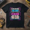 Black t-shirt with neon-style text reading "IF YOU CAN READ THIS SHIRT MY GIRLFRIEND SAYS YOU ARE TOO CLOSE" in