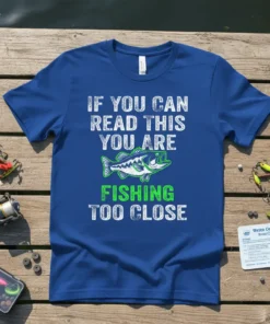 Blue t-shirt with white text "IF YOU CAN READ THIS YOU ARE" and green text "FISHING TOO CLOSE", featuring a