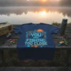 T-shirt with "IF YOU CAN READ THIS YOU ARE FISHING TOO CLOSE" text in blue and orange pixelated font, featuring