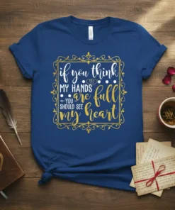White and gold script typography design on a navy blue t-shirt that reads "if you think MY HANDS are full