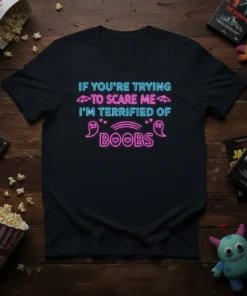 Neon text design on black t-shirt: "IF YOU'RE TRYING TO SCARE ME I'M TERRIFIED OF BOOBS" with ghost and umbrella