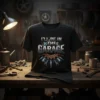 T-shirt with "I'll Be In The Garage" text, featuring a gear, pistons, and wrenches graphic