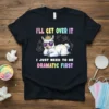 Black t-shirt with colorful text "I'll Get Over It I Just Need To Be Dramatic First" and a crowned, sunglass-wearing