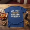 T-shirt with the quote "I'll Just Have The Chicken Tenders" in distressed white and gold lettering, surrounded by small stars