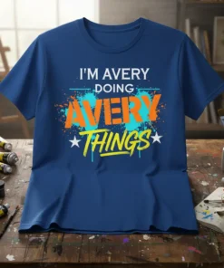 I'M AVERY DOING AVERY THINGS custom name t-shirt with bold orange and yellow lettering and teal paint splatter design