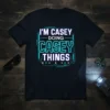 I'm Casey Doing Casey Things text design with blue circuit board graphics on a black t-shirt