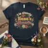 Retro floral t-shirt design with the text "i'm clearly Nana's Favorite" in vintage font, featuring hummingbirds and roses