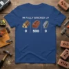 Blue t-shirt with white text "IM FULLY BRICKED UP" above cartoon images of logs (0), bricks (500), and an I-beam