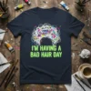 T-shirt with neon green text "I'M HAVING A BAD HAIR DAY" above a chaotic white scribble design with colorful paint