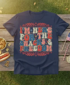 Retro style t-shirt design with bold text "I'M HERE FOR THE SNACKS & FREEDOM" in red, white, and blue, featuring