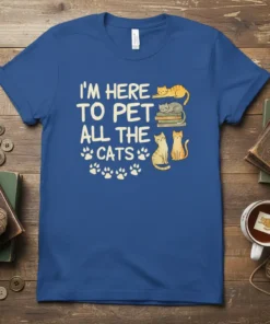 I'm Here To Pet All The Cats quote with cute cat illustrations and paw prints on a blue t-shirt