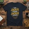 I'm Jackie Doing Jackie Things personalized name quote on a navy t-shirt with gold distressed text and gear graphic