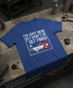 White text "I'm Just Here So I Won't Get Fined" on a blue t-shirt, with a graphic of a car