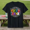 I'm Just Here For Field Day 2025 text and graphics on a black t-shirt, featuring colorful letters and sports icons