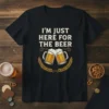 I'm Just Here For The Beer quote on a black t-shirt with graphics of two beer mugs and wheat stalks