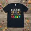 I'M JUST HERE FOR THE CANDY text design with colorful candy graphics and stars on a black t-shirt