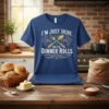 I'm Just Here For The Dinner Rolls quote with crossed fork and spoon graphic on a blue t-shirt
