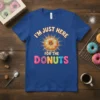 T-shirt with "I'm Just Here For The Donuts" text and a colorful donut graphic, set against a blue background
