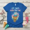 Blue t-shirt with colorful text "I'm Just Here For The" above a graphic of a multi-colored ice cream cone with