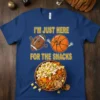 T-shirt with text "I'm Just Here For The Snacks" featuring cartoon football and basketball characters above a bowl of popcorn