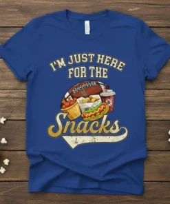 Blue t-shirt with "I'm Just Here For The Snacks" text and football game day food graphics