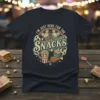 I'm Just Here For The Snacks t-shirt design with vintage circus-style graphics featuring popcorn, cupcakes, and cartoon mouse ears