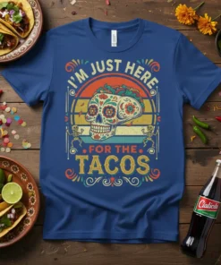 I'm Just Here For The Tacos shirt featuring a colorful sugar skull and retro sunset graphic, with skeleton figures
