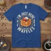 I'm Just Here For The Waffles text with a stack of syrup-covered waffles graphic, strawberries, blueberries, and whipped cream