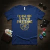 I'm Just Here To Pay For Everything text with gold gear graphic on a blue t-shirt