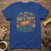 I'm Just My Dog's Treat Treat Dealer text on a royal blue t-shirt, featuring decorative elements and paw prints