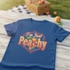 I'm Just Peachy text with a retro peach graphic on a blue t-shirt
