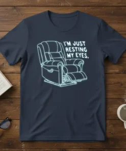 I'm Just Resting My Eyes quote with a neon-style outline of a recliner chair on a navy t-shirt